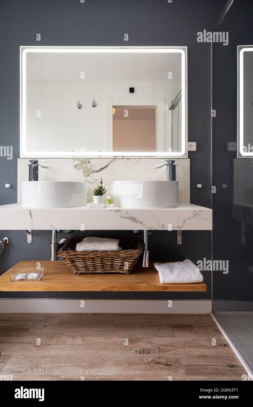 Interno di bagno luminoso e moderno con specchio con luce Foto Stock