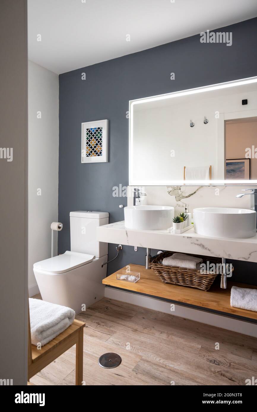 Interno di bagno luminoso e moderno con specchio con luce Foto Stock