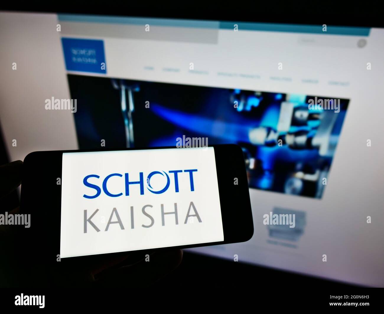 Persona che tiene il telefono cellulare con il logo della società indiana di imballaggio Schott Kaisha Pvt. Ltd. Sullo schermo davanti alla pagina Web. Mettere a fuoco il display del telefono. Foto Stock