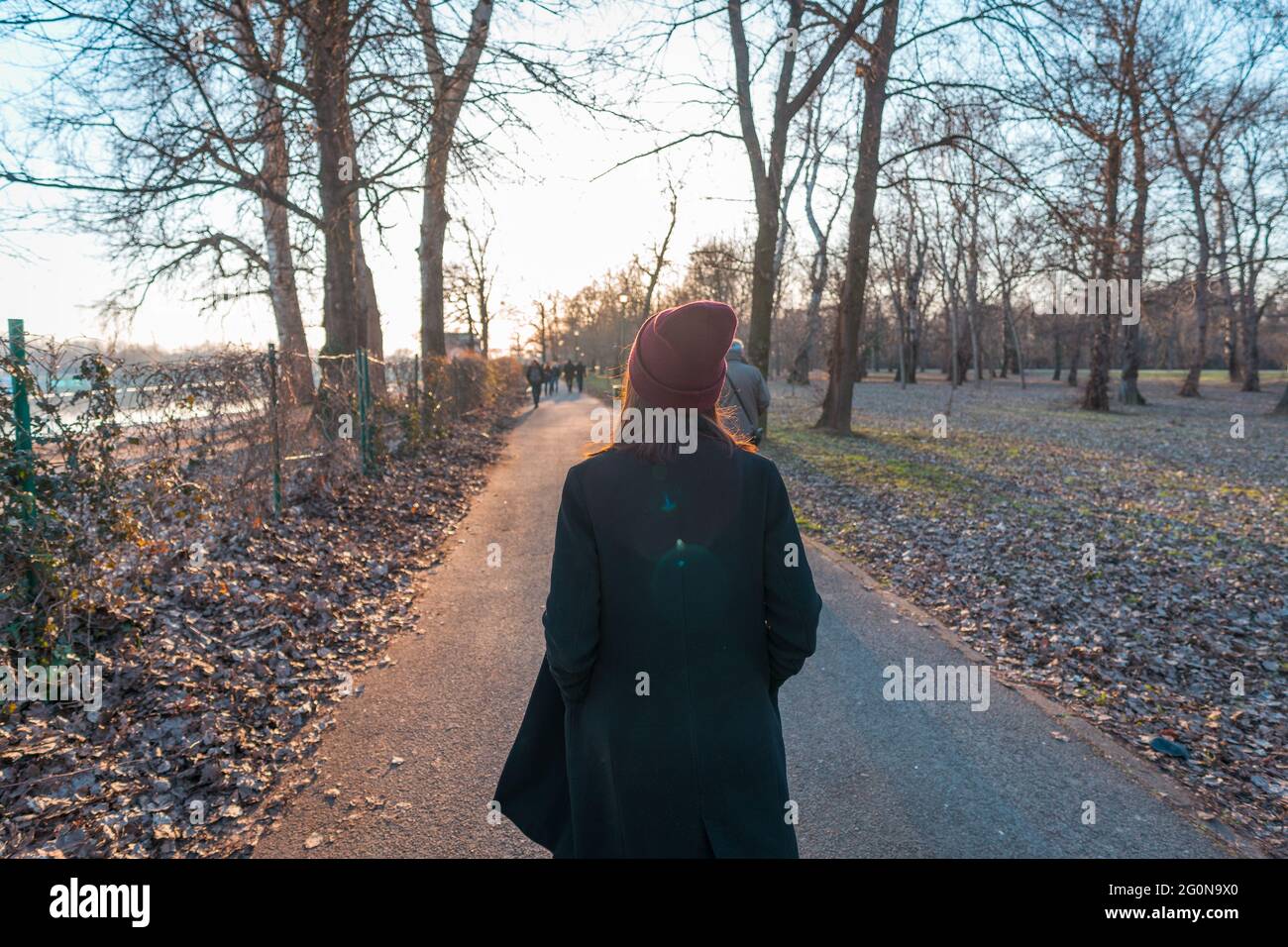 Giovane ragazza in un cappotto invernale facendo una passeggiata in un parco naturale Foto Stock