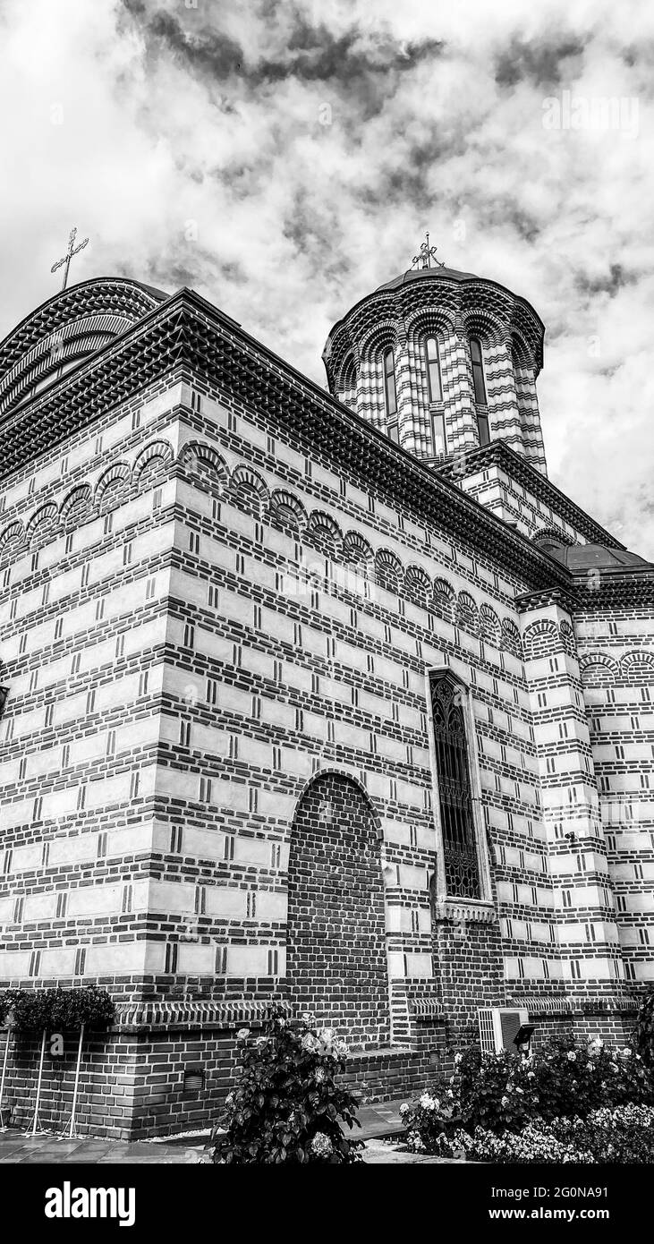 Bianco e nero classica vecchia chiesa ortodossa cristiana rumena con cielo e nuvole Foto Stock