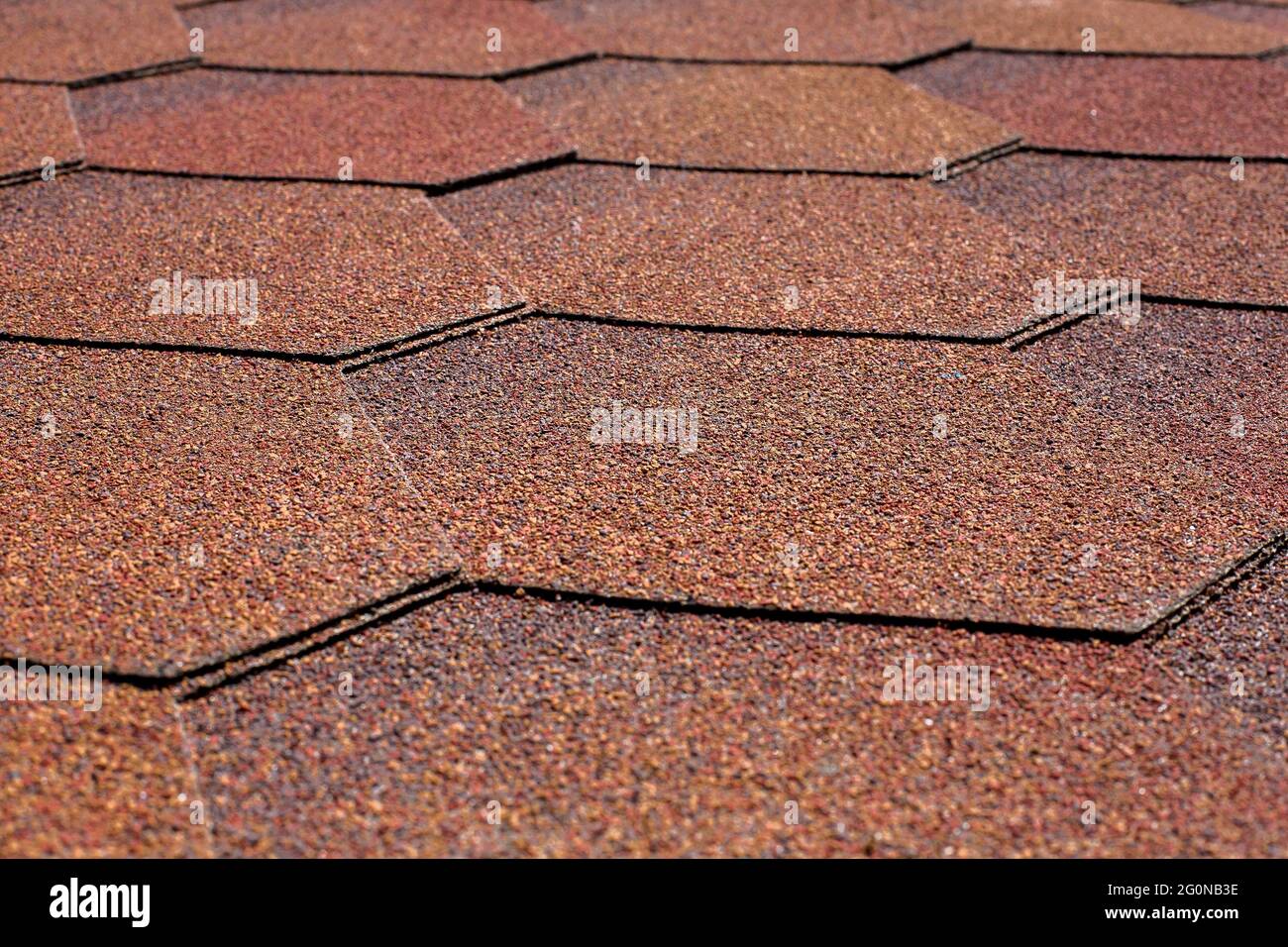 copertura protettiva del tetto con tegole bituminose di forma esagonale di primo piano del materiale di copertura. Foto Stock