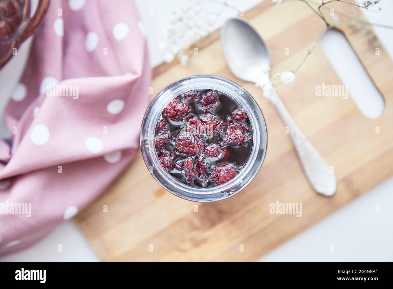 Concetto di cibo antivirale. Sano processo di fermentazione del miele con mirtillo rosso. Conservante alimentare a casa, accogliente, rustico piatto posato. Delizioso concetto di ricetta. Vista dall'alto Foto Stock