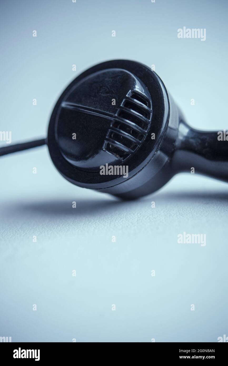 Ricevitore di un vecchio telefono nero su sfondo bianco Foto Stock