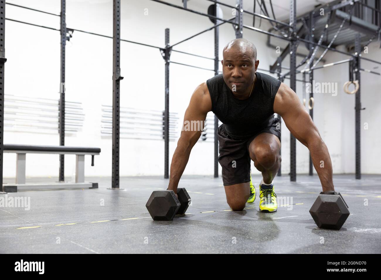 Uomo nero atletico che fa l'addestramento del peso in palestra. Stile di vita sano e sport. Spazio per il testo. Foto Stock