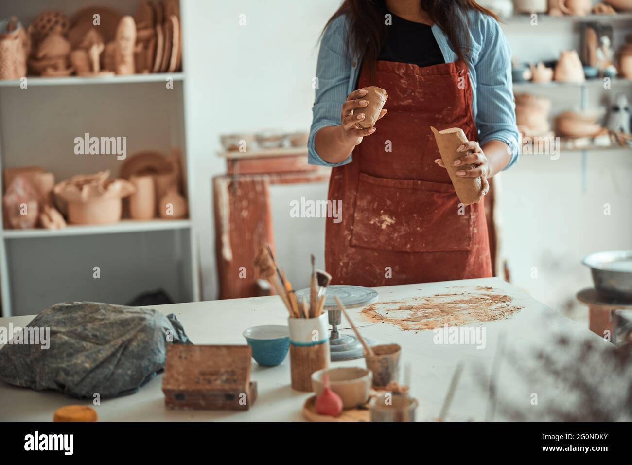 Ceramista femminile in grembiule che lavora in studio di ceramica Foto  stock - Alamy