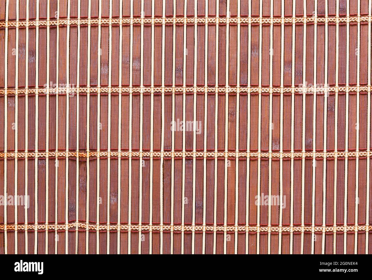 Immagine di sfondo. L'elemento principale è un tappetino da tavolo in legno o doghe di bambù unite con filo. Foto Stock