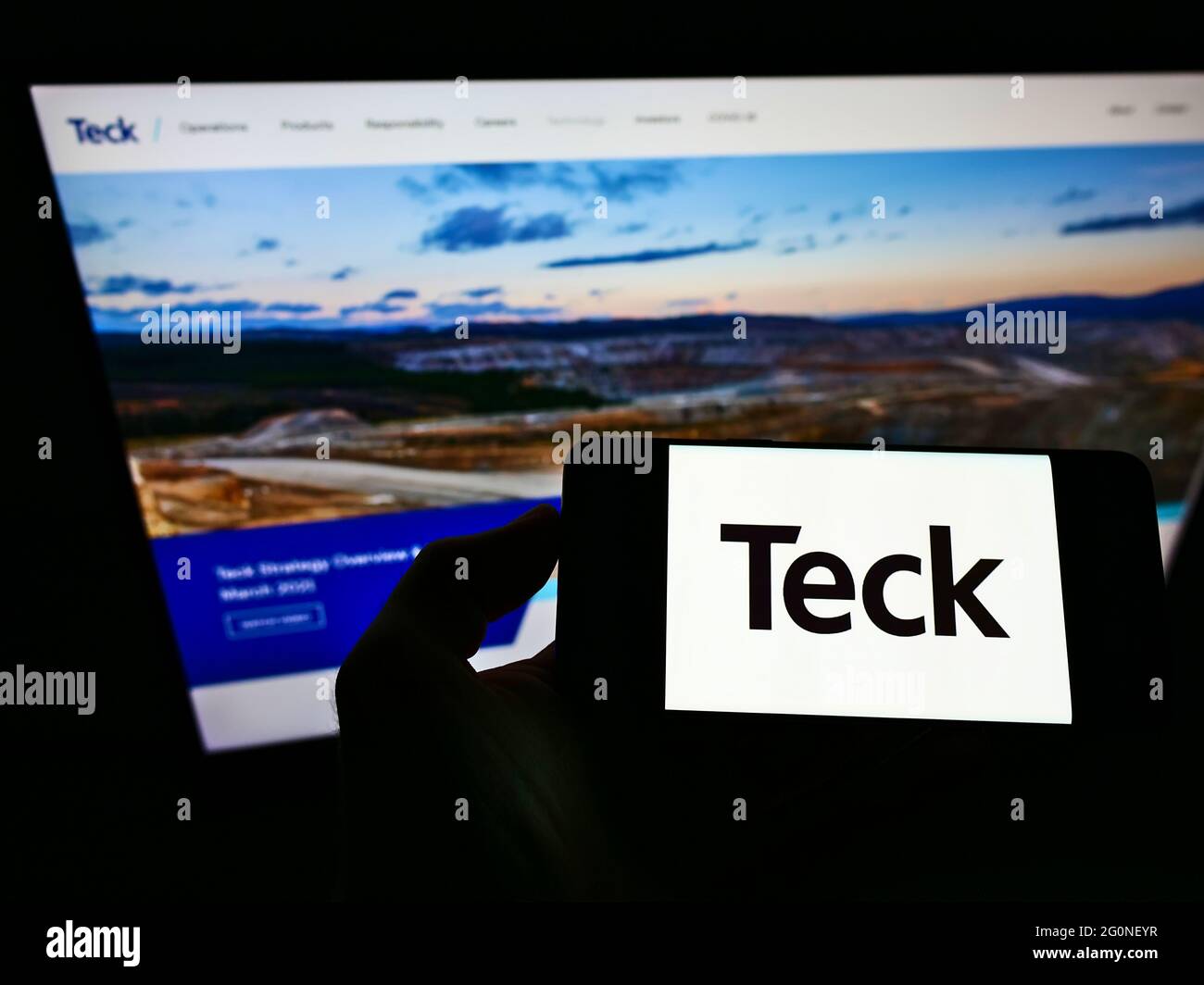 Persona che detiene smartphone con il logo della società mineraria canadese Teck Resources Limited sullo schermo di fronte al sito Web. Mettere a fuoco il display del telefono. Foto Stock