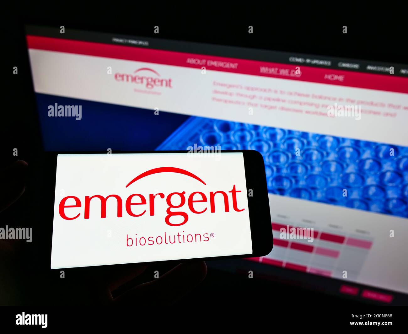 Persona che tiene il telefono mobile con il logo della società americana emergente BioSolutions Inc. Sullo schermo davanti alla pagina web. Mettere a fuoco il display del telefono. Foto Stock