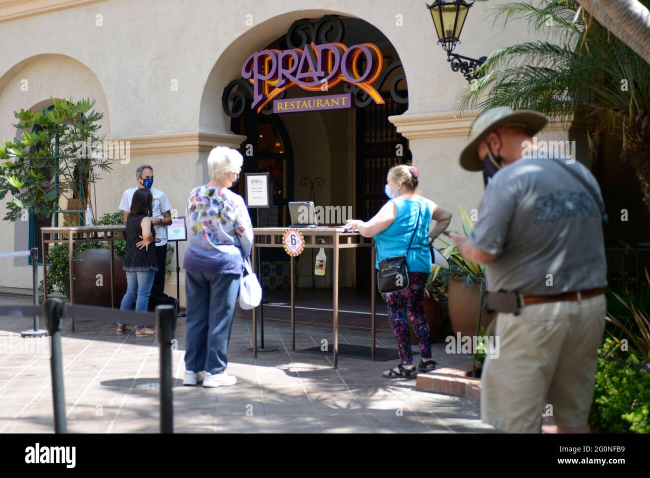Persone che indossano maschere in piedi fuori del Ristorante Prado in attesa di un tavolo durante i primi giorni post-covid a Blboa Park, San Diego, CA Foto Stock