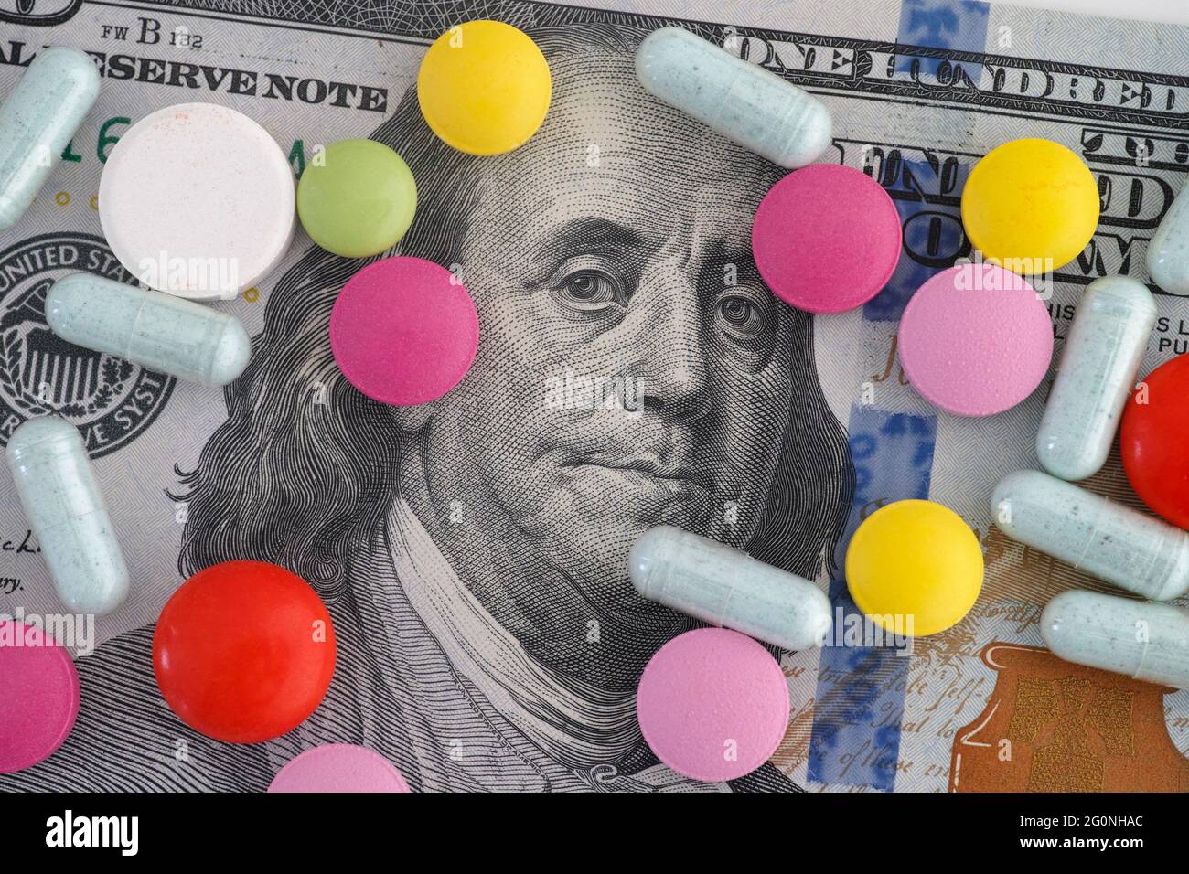 Un conto di cento dollari con pillole mediche su di esso. Primo piano. Foto Stock