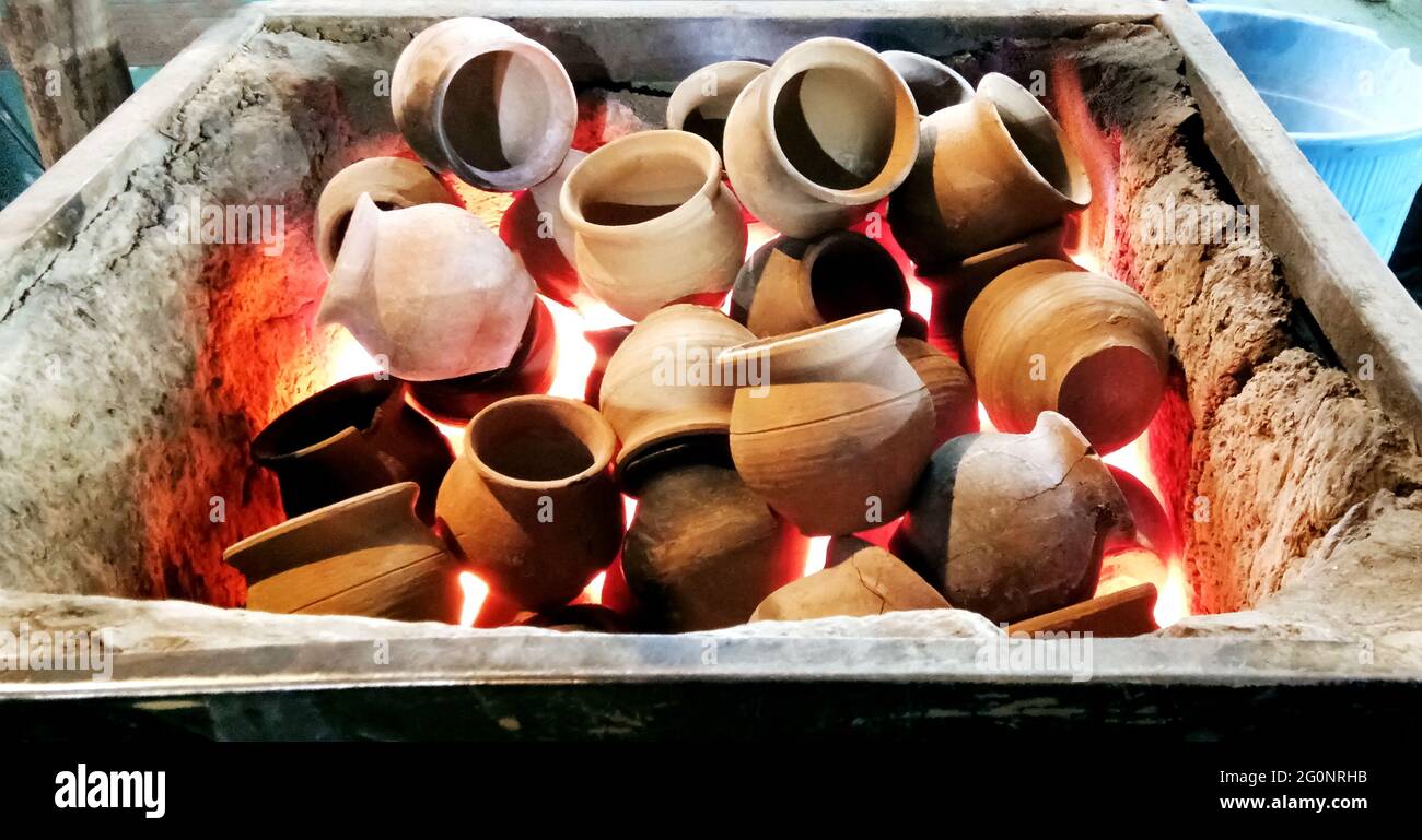 Riscaldamento creta pentole in carbone per fare tè in india Foto Stock