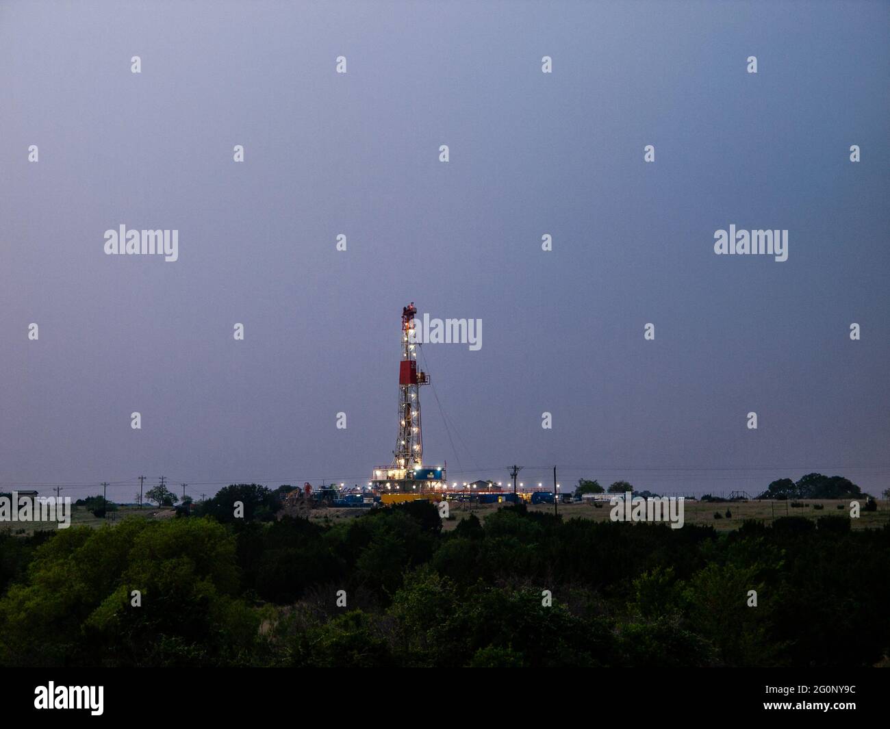 Le luci brillano su un carro di perforazione a olio per il gas naturale nel Texas meridionale Eagle Ford Field a sud di San Antonia. La fratturazione ad alta pressione ha aperto nuovi e vecchi giacimenti petroliferi in Texas e ha contribuito a allontanare il paese dall'uso del carbone. Foto Stock