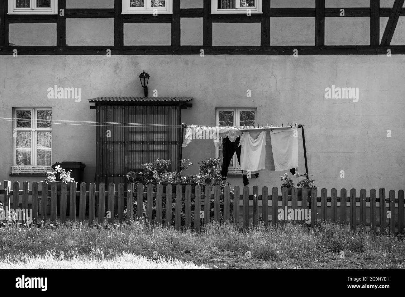 JUETERBOG, GERMANIA - 23 MAGGIO 2021: Varie bucato è in fase di asciugatura all'esterno di fronte alla vecchia casa. Bianco e nero. Foto Stock