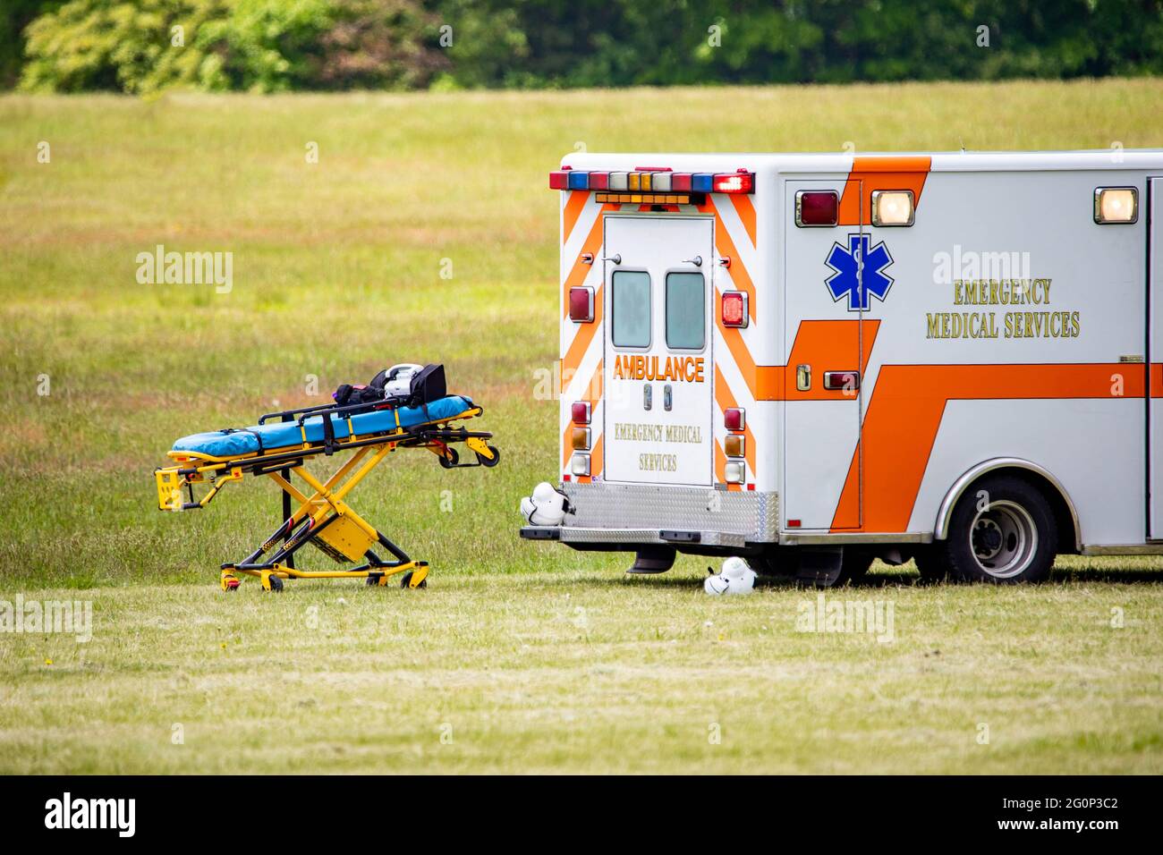Barella medica vuota con auto ambulanza sul campo nessuno Foto Stock