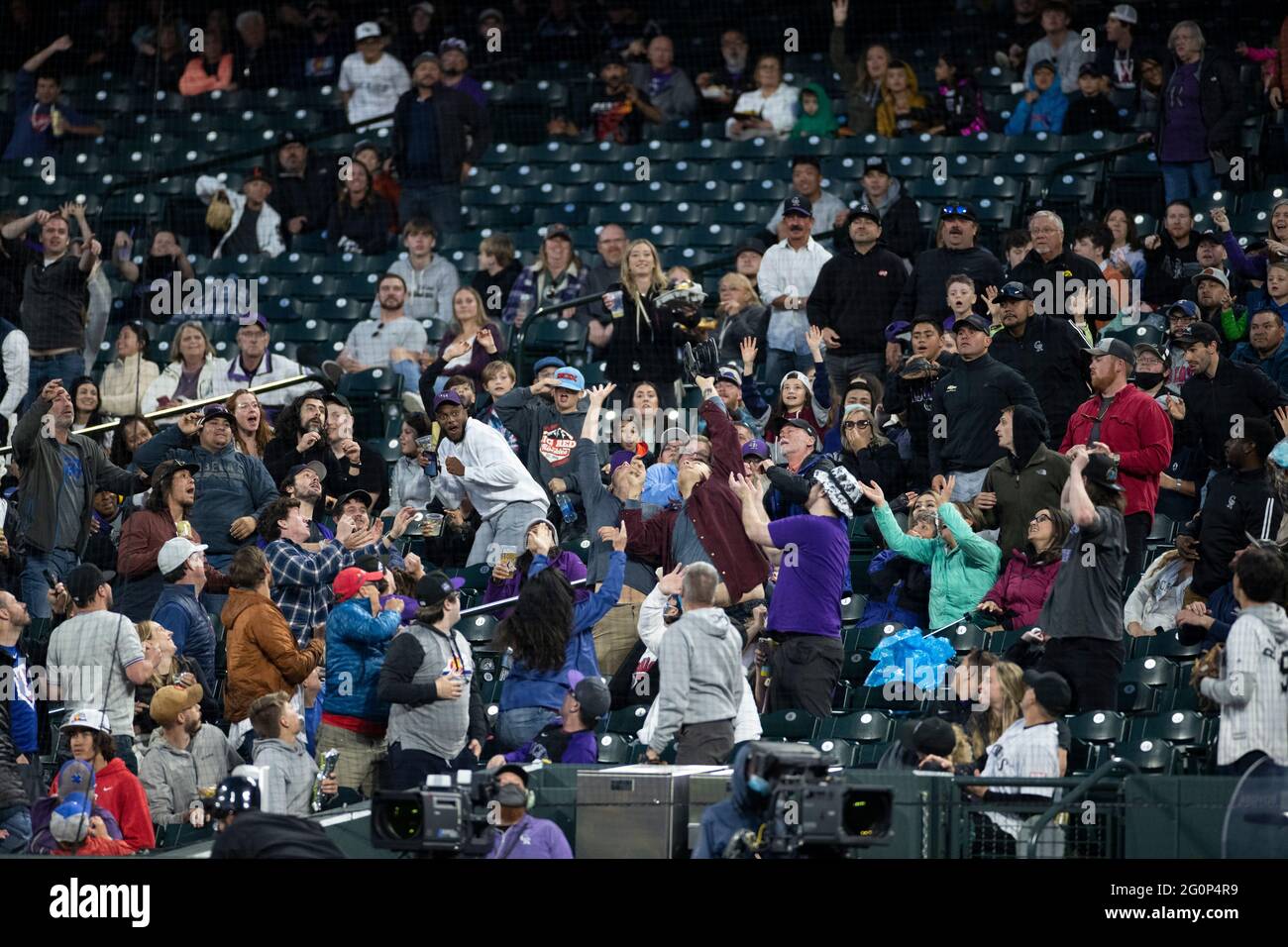 I fan si sfuggirono per una palla fallo durante una partita di stagione regolare della MLB tra i Texas Rangers e Colorado Rockies, martedì 1 giugno 2021, a Denver. (BR Foto Stock