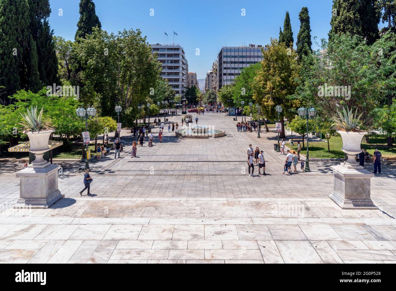 Atene, Attica, Grecia. Piazza Syntagma, nel centro di Atene, a un'ora di punta piena di persone che camminano o riposano sulle panchine Foto Stock