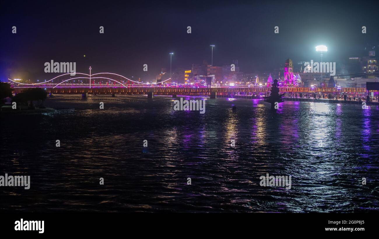 Bella vista notturna della città di Haridwar durante il più grande festival indiano Kumbh Mela. Banca del fiume Ganga è illuminato di luci. Il fiume Santo dell'India. Filmati 4k di alta qualità Foto Stock
