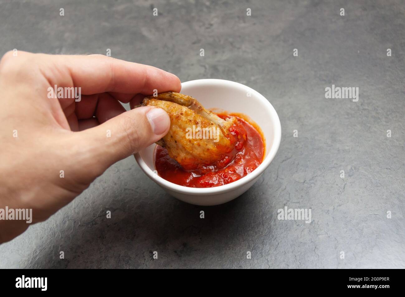 Ali di pollo di bufala calde e piccanti. Ali di pollo cotte in mano. Ali di pollo fritte profonde Foto Stock