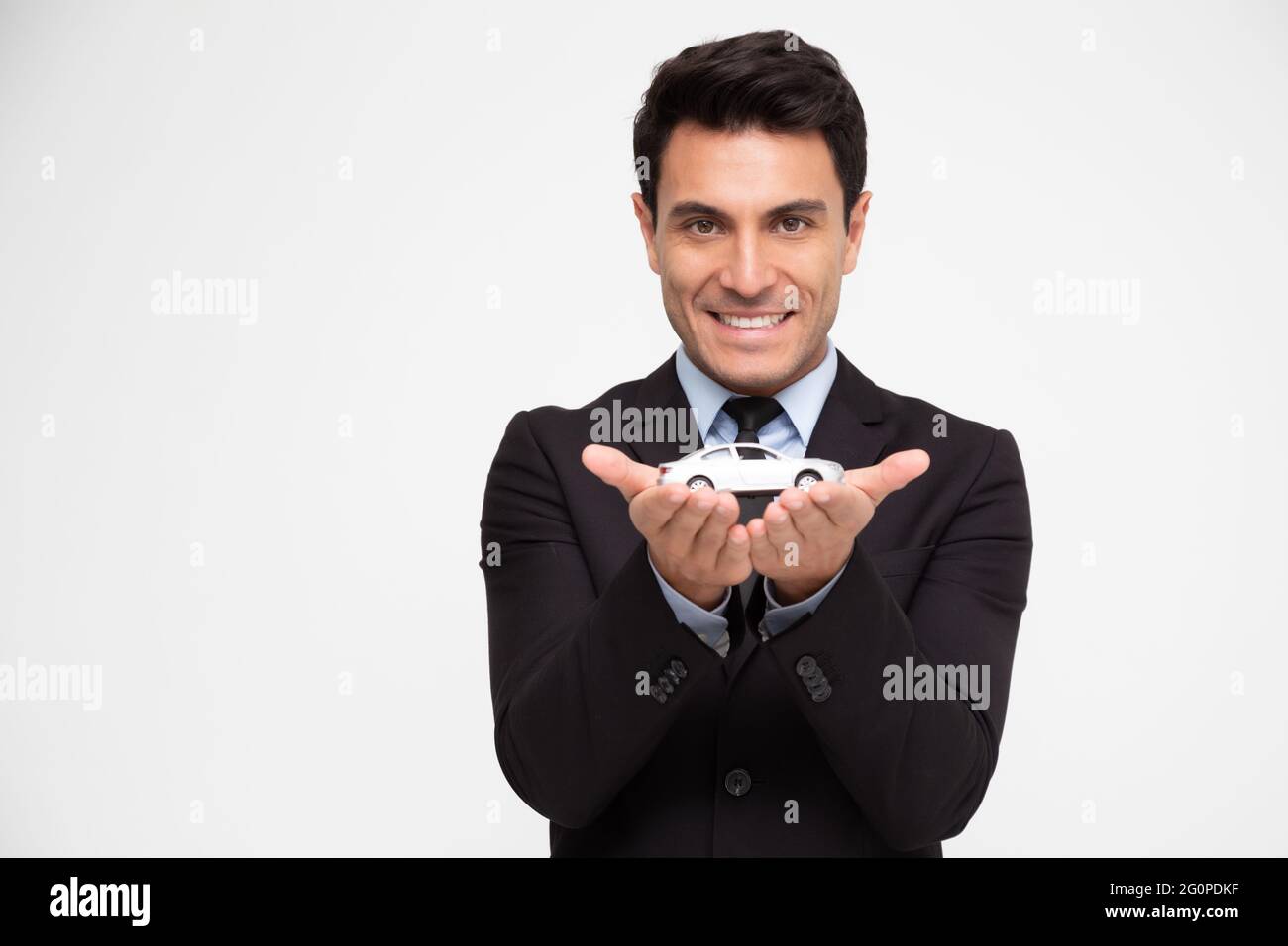 Uomo d'affari con gesto protettivo e auto, concetti di assicurazione auto Foto Stock