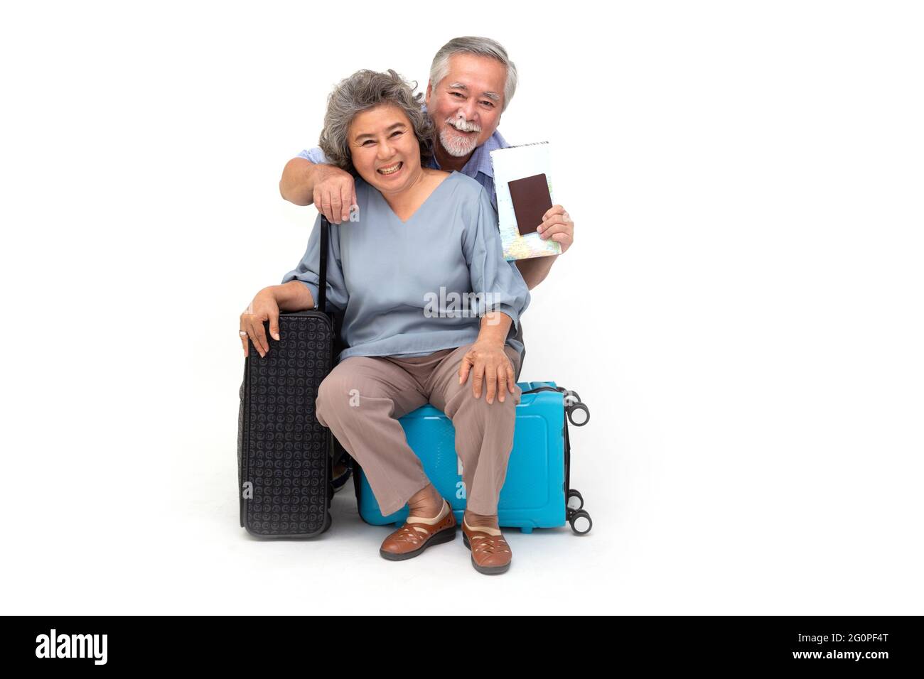 Coppia anziana asiatica seduta su borsa da viaggio isolato su sfondo bianco, viaggiatori e concetto di turismo Foto Stock