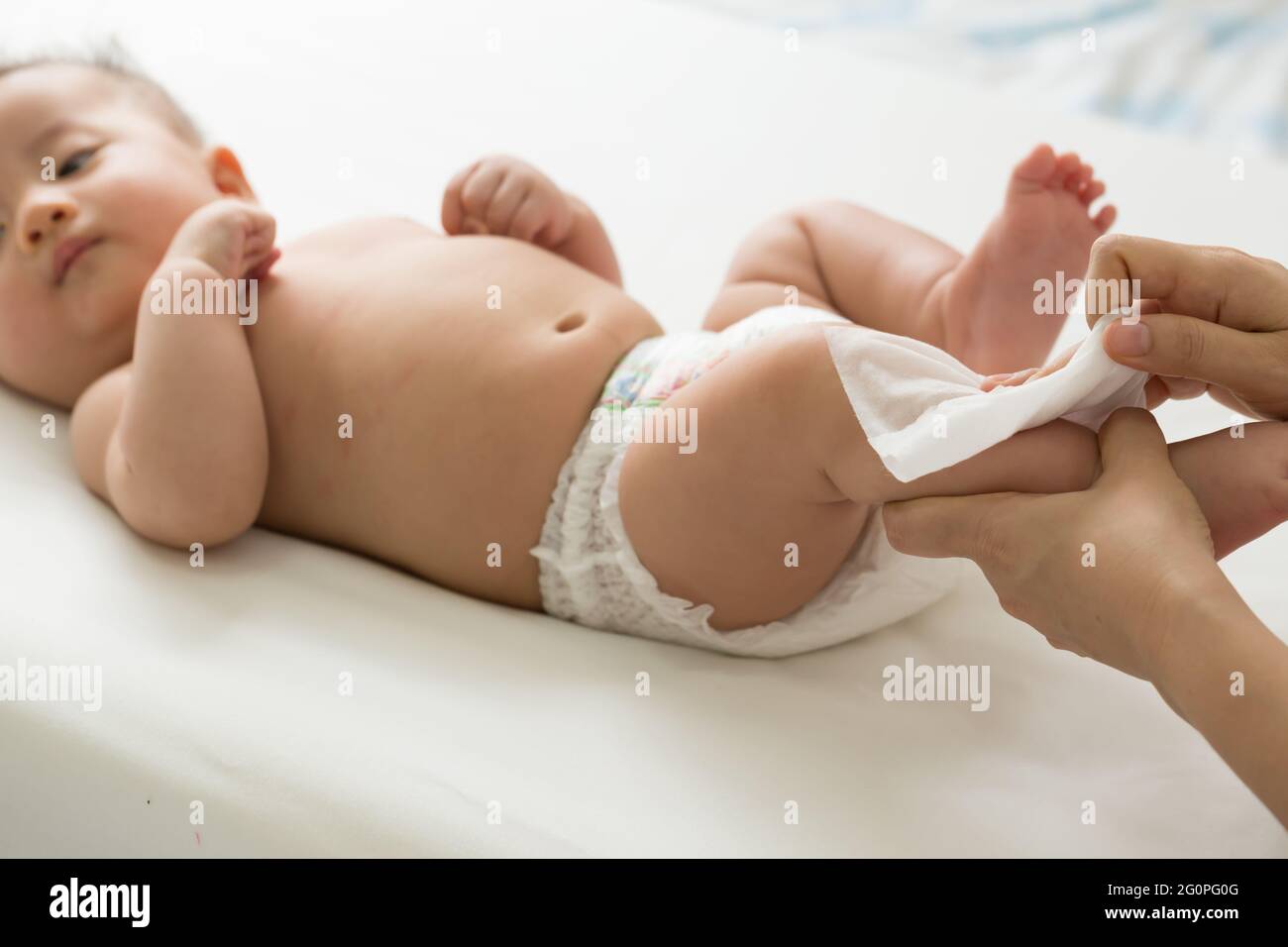 Mom pulizia e strofinare body baby da tessuto umido durante il cambio di pannolini o pannolini e strofinando le mani o il viso o la gamba, igiene personale per la madre e per il Foto Stock