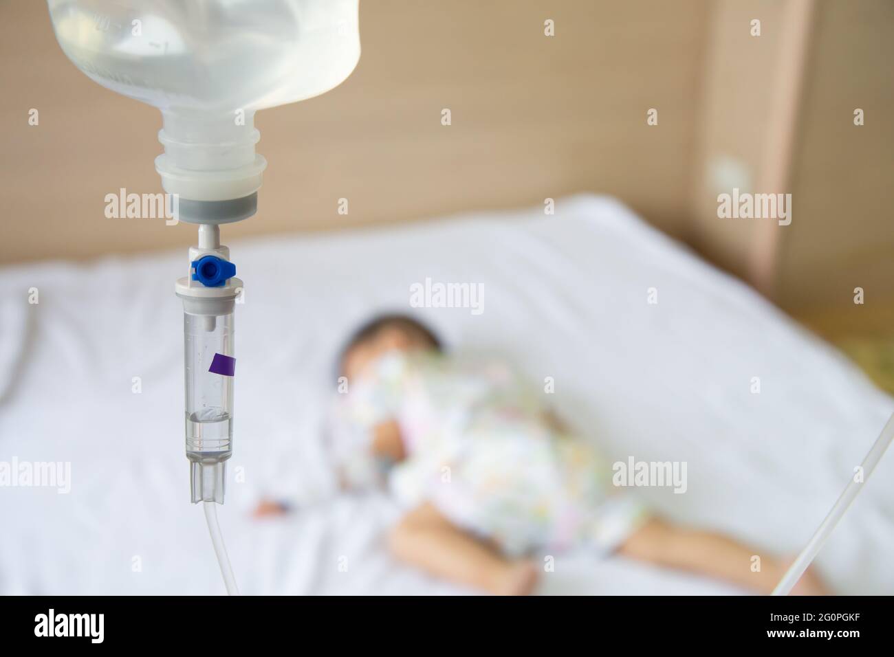 Asian bimbo che dorme sul letto con set per infusione al bambino dipartimento dell'ospedale. I bambini con malattie infettive IPD, pneumococciche invasive Dis Foto Stock