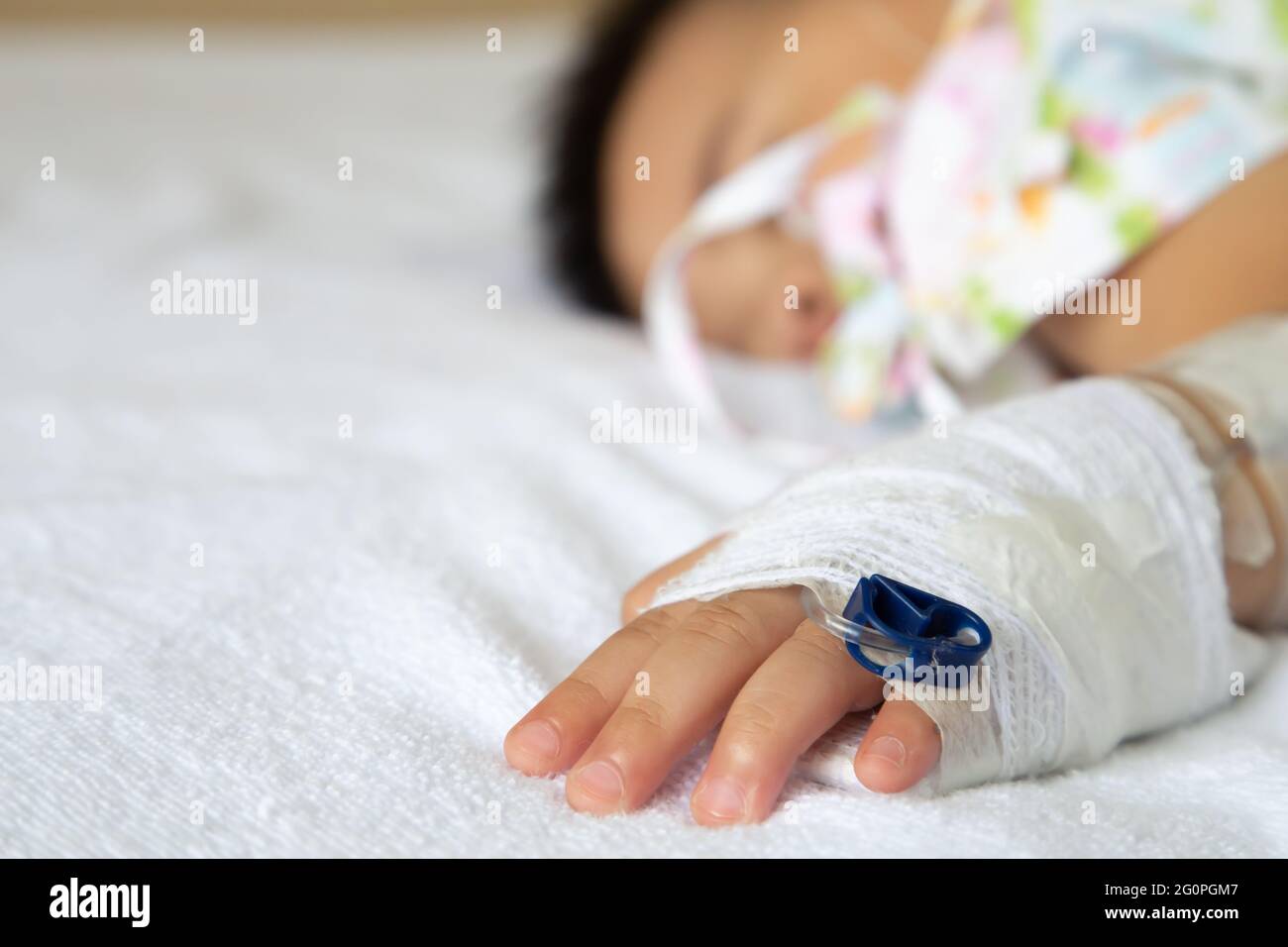 Asian bimbo che dorme sul letto con set per infusione al bambino dipartimento dell'ospedale. I bambini con malattie infettive IPD, pneumococciche invasive Dis Foto Stock