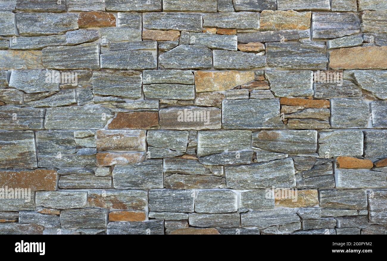 Particolare di un rivestimento esterno della parete fatto di mattoni di fronte in pietra aspetto Foto Stock