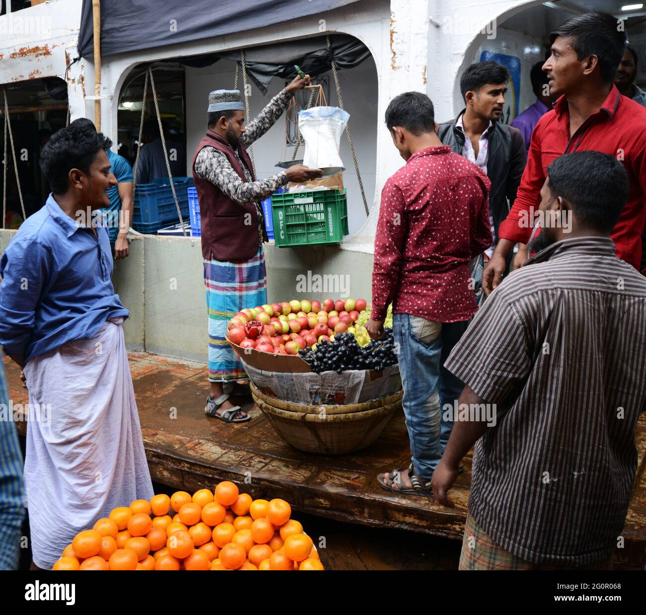 Vendita di mele e arance sul molo dei traghetti sul fiume Buriganga a Dhaka, Bangladesh. Foto Stock