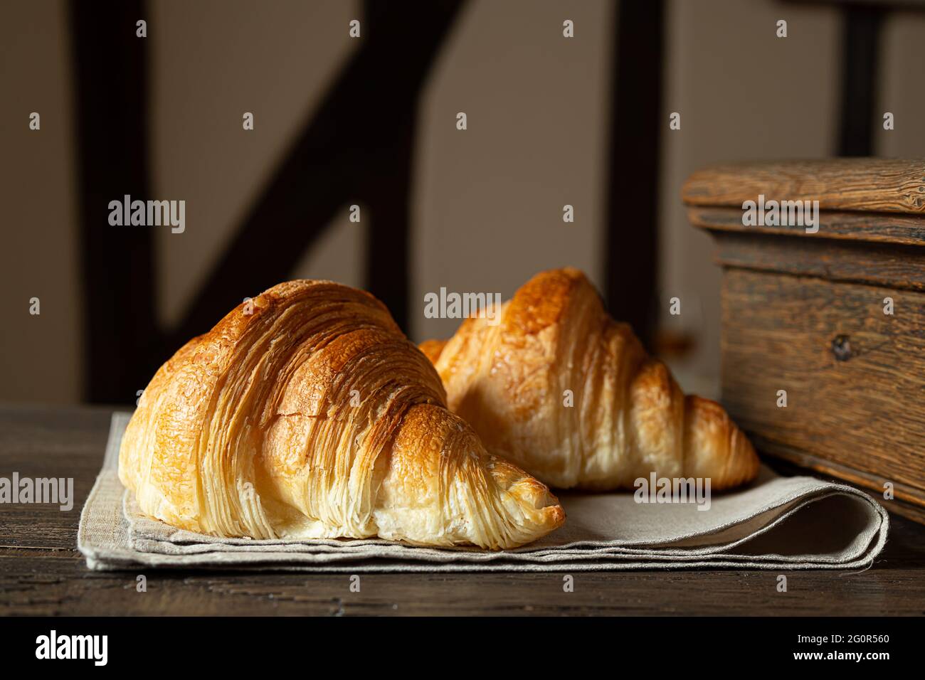 Due croissant francesi freschi su un vecchio tavolo Foto Stock