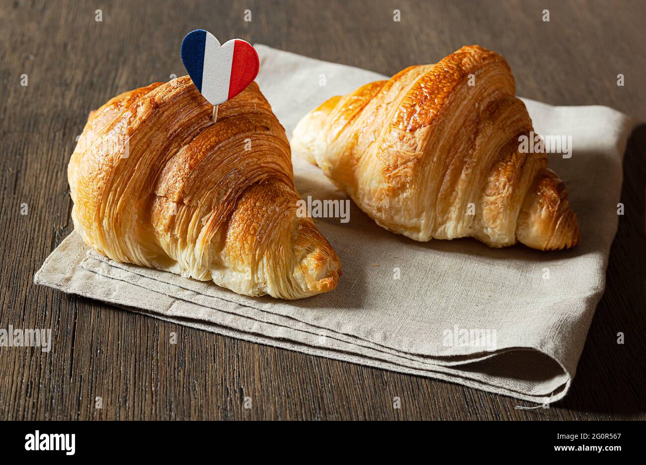 Due croissant e un cuore nei colori della bandiera francese su un tavolo Foto Stock