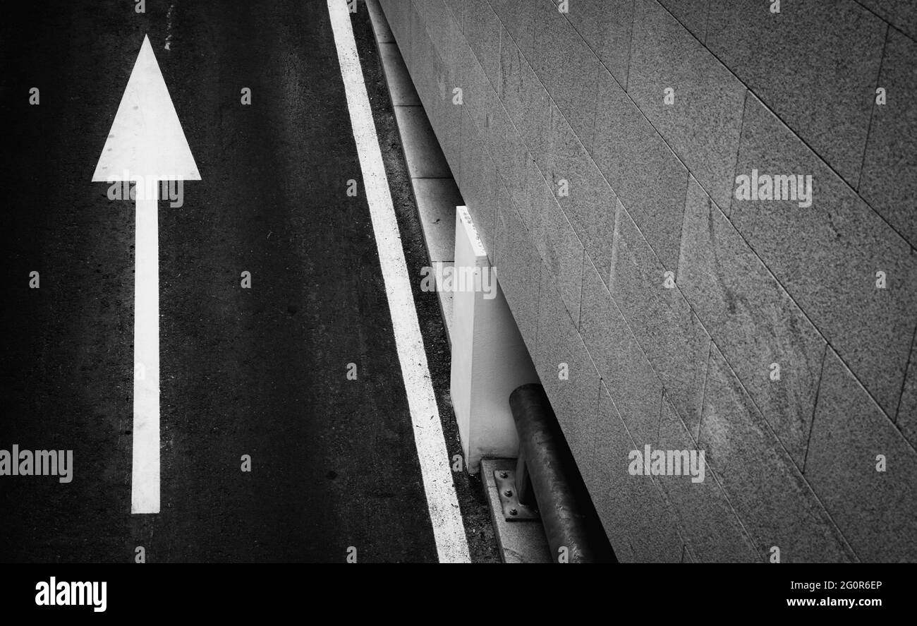 Segno di freccia sulla strada Foto Stock