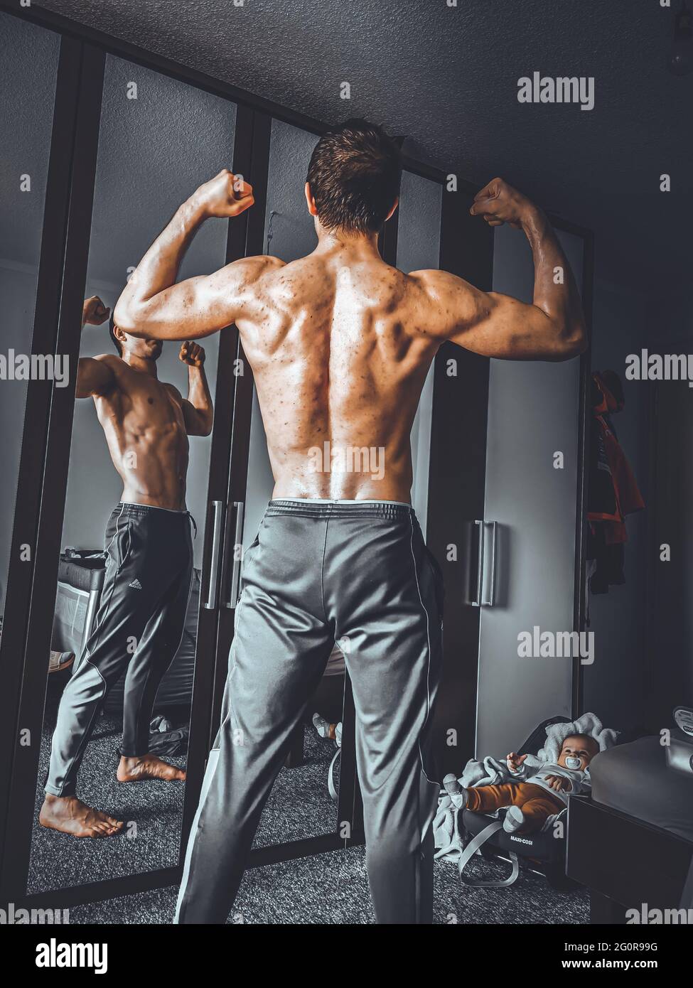 Calisteniche che si posano dalla schiena con il figlio sullo sfondo Foto Stock