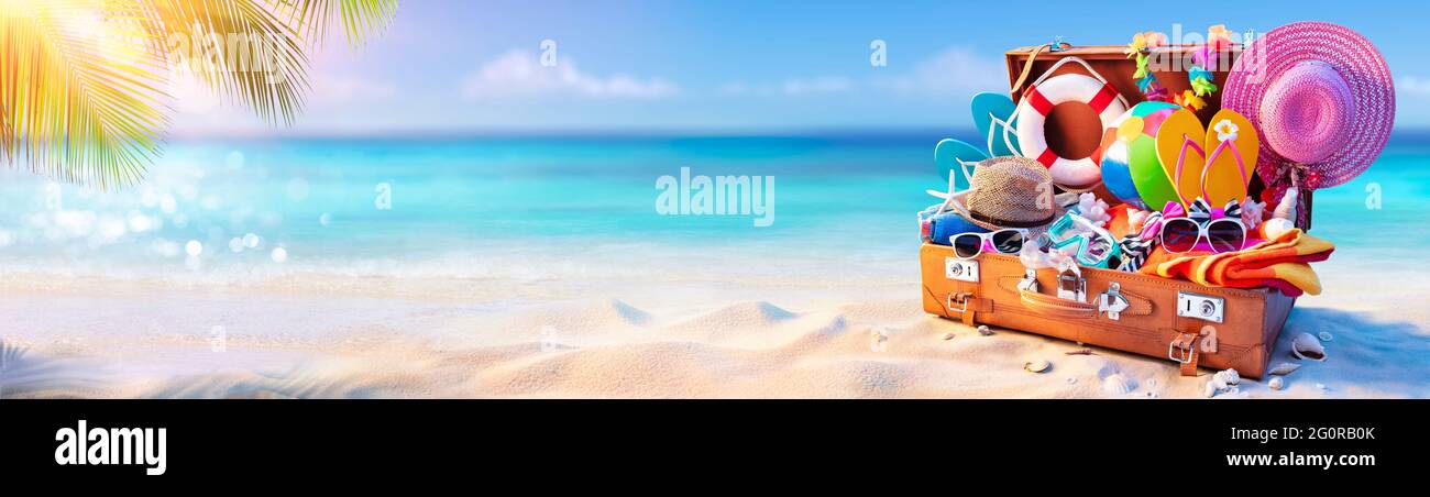 Vacanza in spiaggia - valigia di viaggio sulla sabbia tropicale con il mare soleggiato Foto Stock