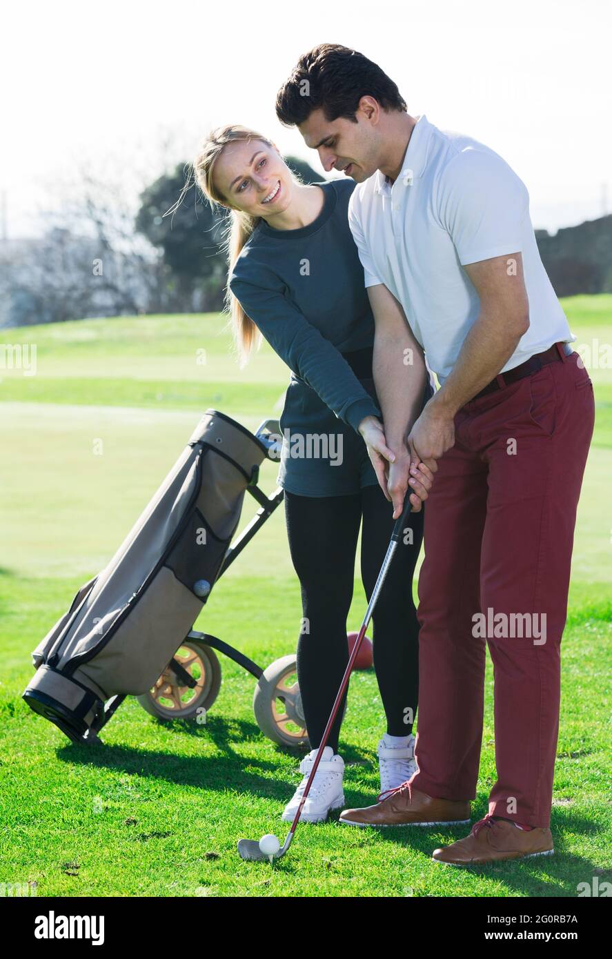 Il giocatore di golf insegna l'uomo destra disposizioni golf club Foto Stock