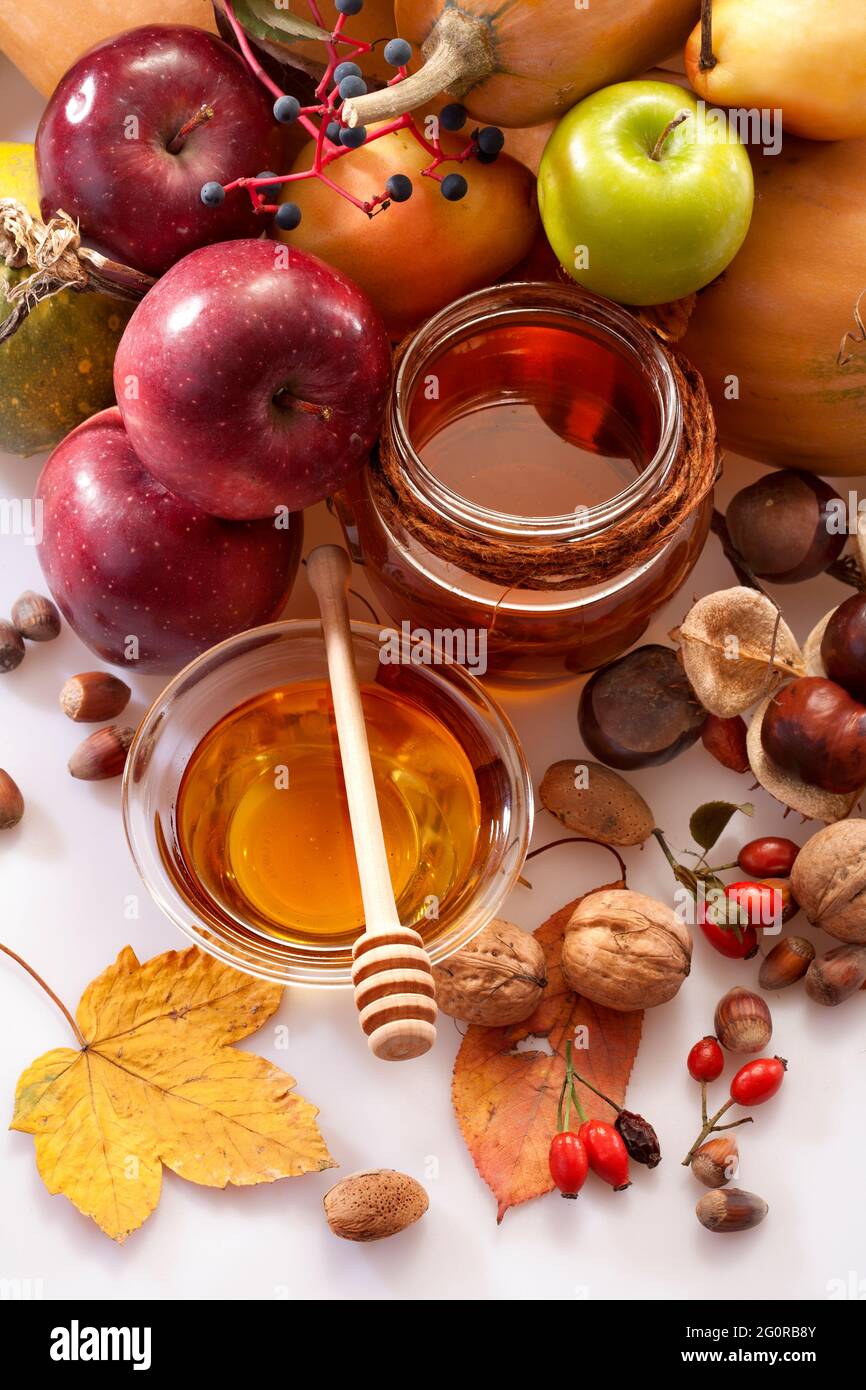 miele, mele e frutti autunnali su sfondo bianco Foto Stock