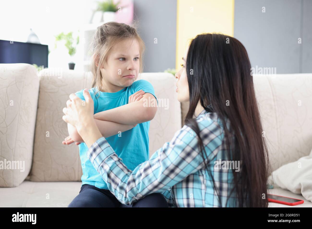 Triste figlia offesa seduta sul divano, tornando alla madre dopo la disputa a casa Foto Stock