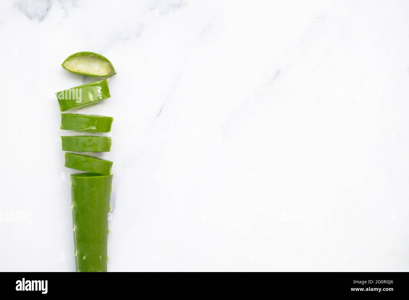 Gambo verde naturale di aloe vera tagliato a fette. Salute e benessere sfondo Foto Stock