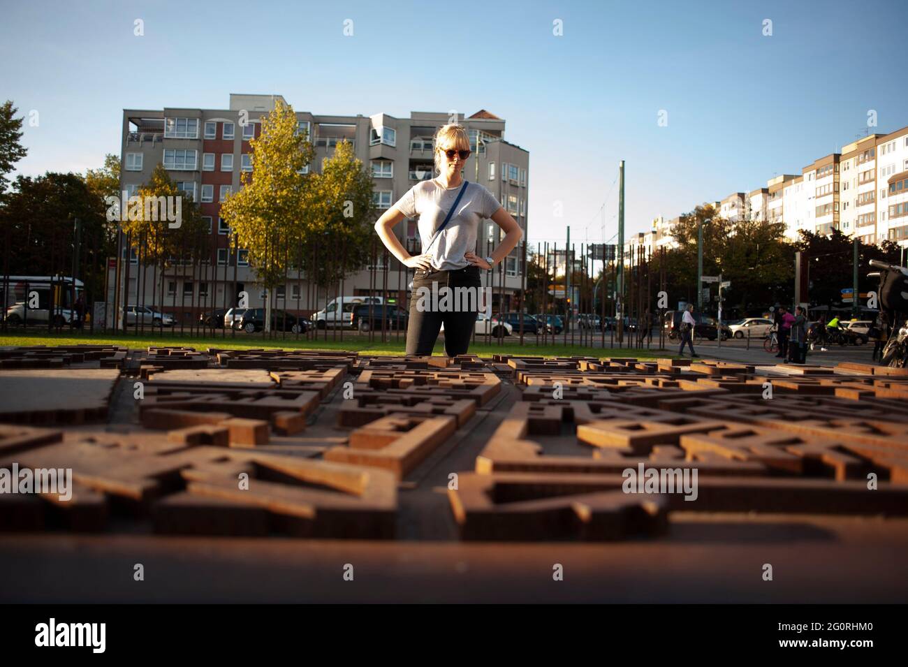 Una donna si trova in un parco a Berlino, in Germania, guardando una mappa 3D della zona e vedendo dove il Muro di Berlino ha diviso la città. Foto Stock