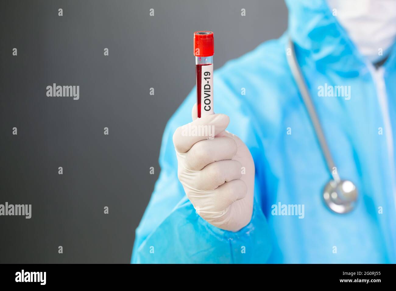 Medico scienziato che indossa DPI e tiene il sangue di persona infetta covid-19 per la ricerca sul vaccino prevenire o trattare il nuovo coronavirus SARS-COV-2, Phys Foto Stock