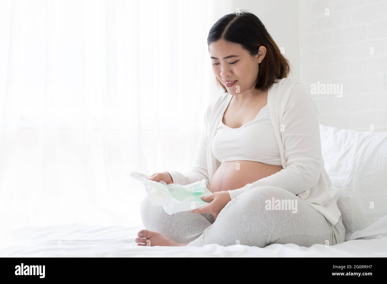 Donne incinte asiatiche scelta del formato del pannolino per il bambino, pianificazione per il neonato Foto Stock