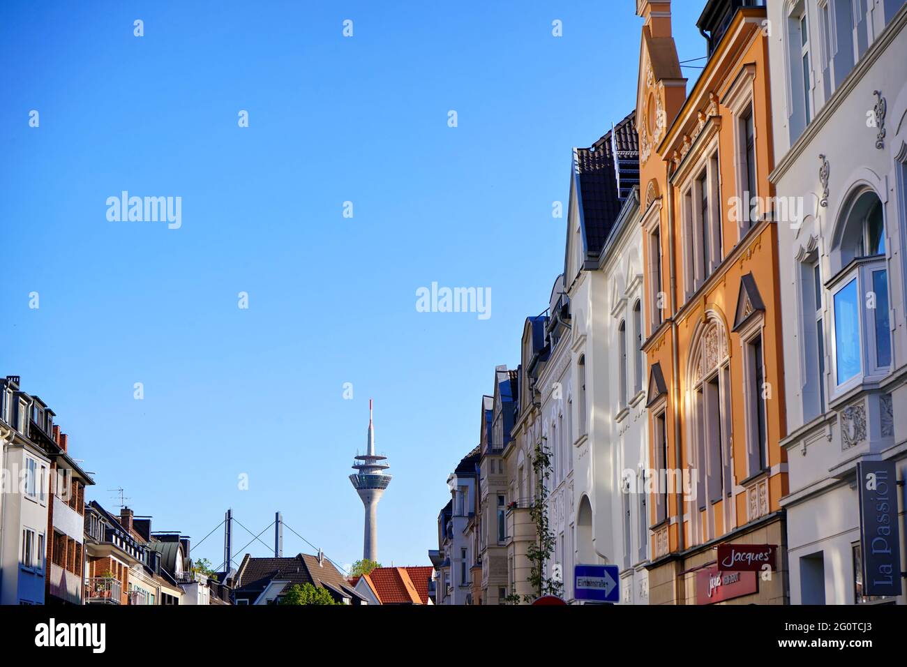 Belle case private colorate nel quartiere di Oberkassel a Düsseldorf, vicino al fiume Reno, con la torre del Reno sullo sfondo. Foto Stock