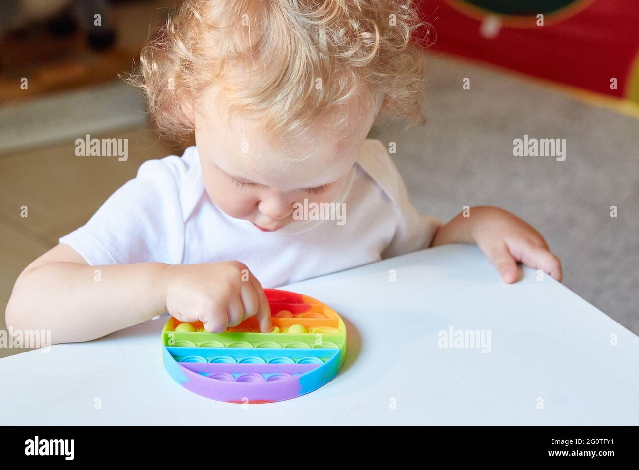 Popolare giocattolo anti stress Pop it. Bambino che gioca con il giocattolo Pop IT Fidget. Felice infanzia, giochi educativi popolari Foto Stock