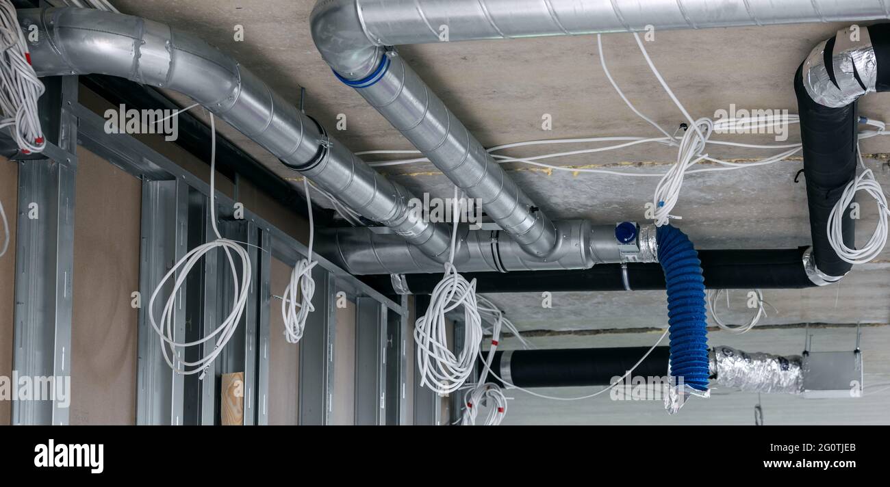 installazione del cablaggio elettrico e del sistema di condotti di ventilazione dell'aria nell'edificio Foto Stock