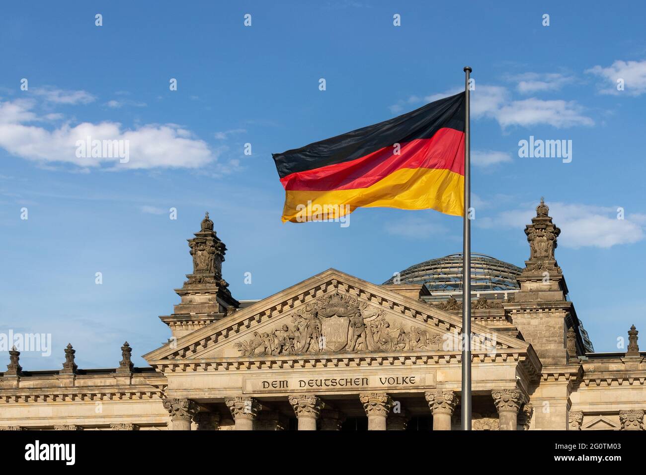 Bandiera tedesca di fronte al Parlamento tedesco (Bundestag) - edificio del Reichstag - Berlino, Germania - il testo dice: Al popolo tedesco Foto Stock