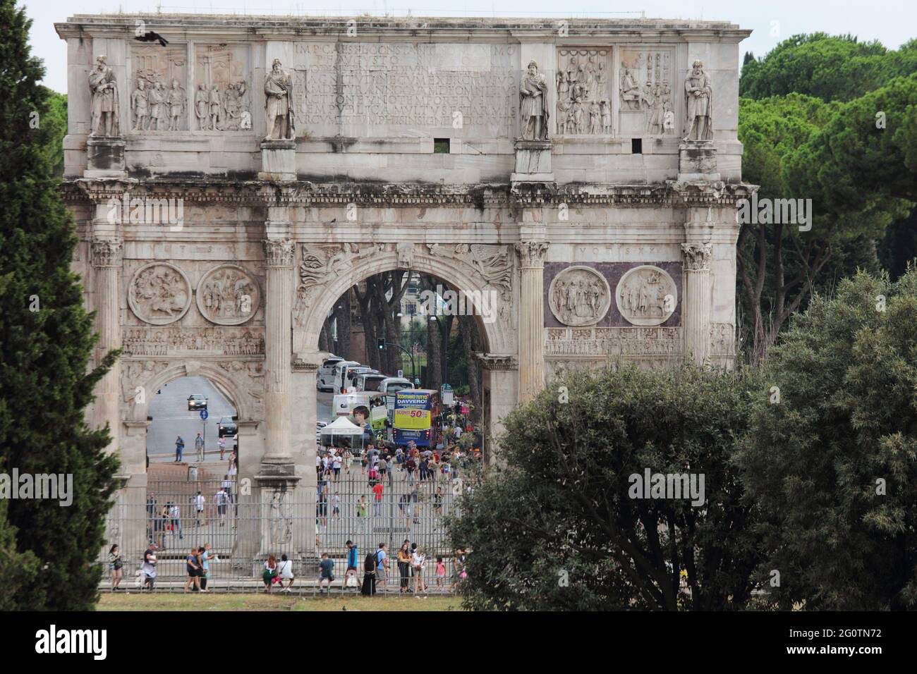 Persone all'Arco di Costantino a Roma, Italia. Questo arco trionfale è stato costruito nel 312 d.C. ed è ora elencato come Patrimonio dell'Umanità dell'UNESCO Foto Stock