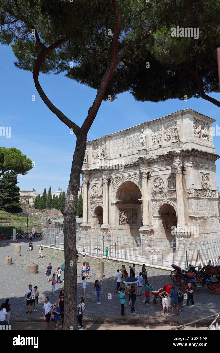 Persone all'Arco di Costantino a Roma, Italia. Questo arco trionfale è stato costruito nel 312 d.C. ed è ora elencato come Patrimonio dell'Umanità dell'UNESCO Foto Stock