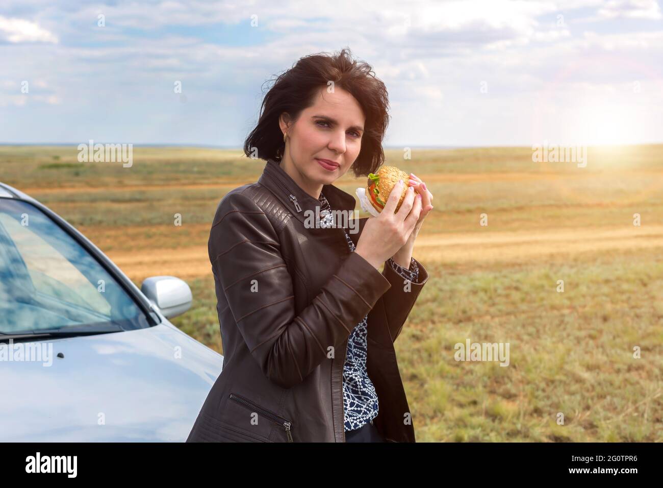 Una donna in natura con la testa gettata indietro gode di un pasto. Foto Stock