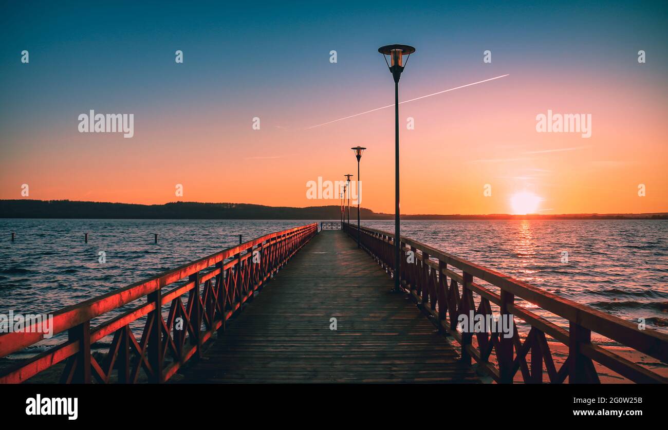 Molo sulla spiaggia in estate in Polonia al tramonto in prospettiva punto di fuga. Colorato relax sulla riva durante una passeggiata. Foto Stock